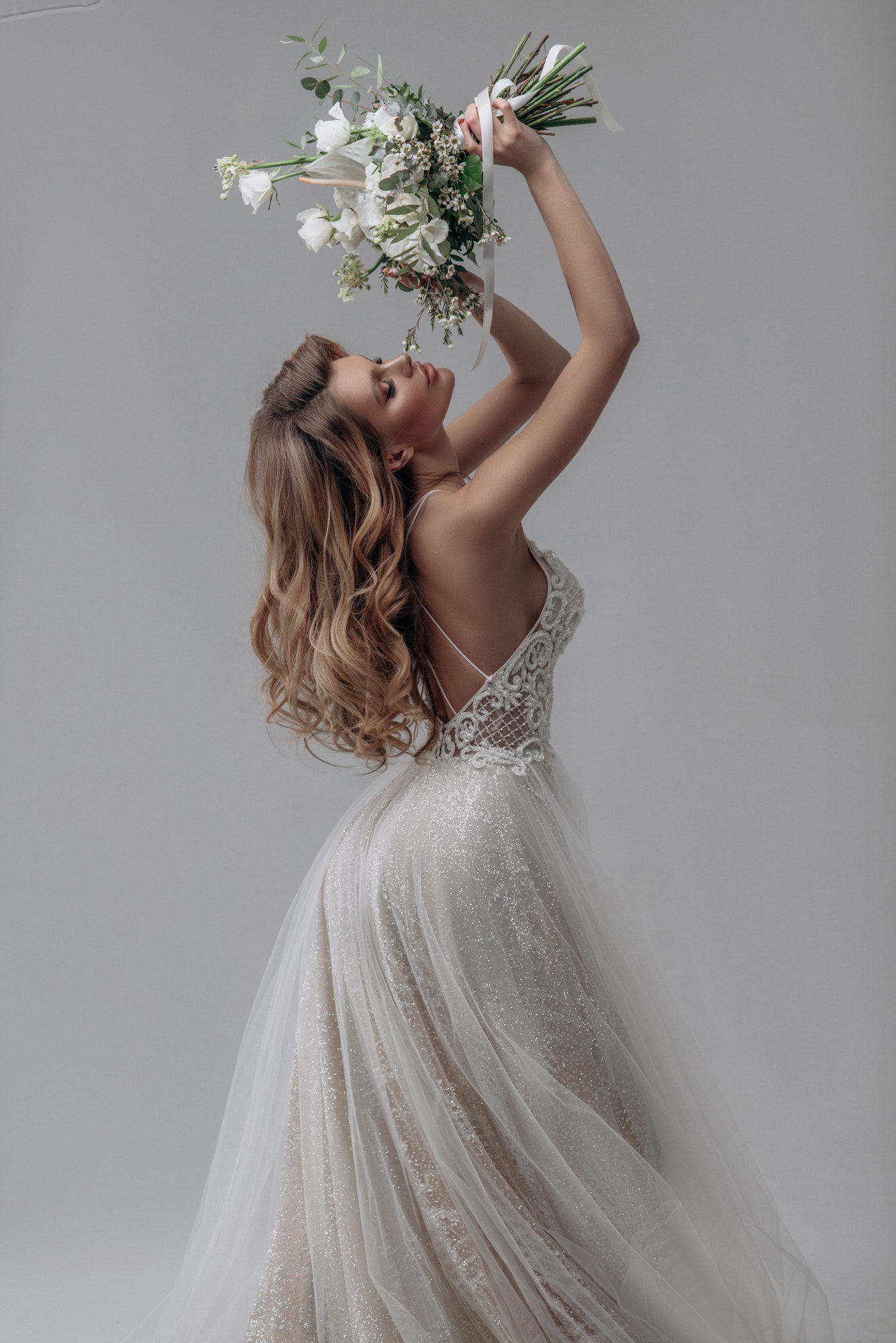 beautiful sexy blonde bride posing in wedding dress in white room